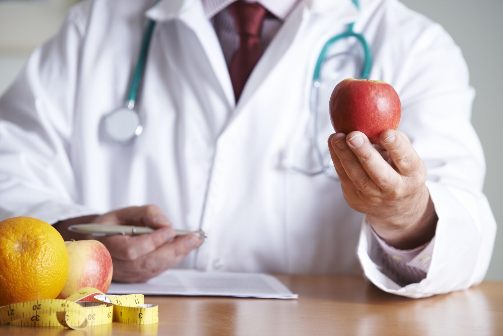 A doctor holding an apple in his hand.